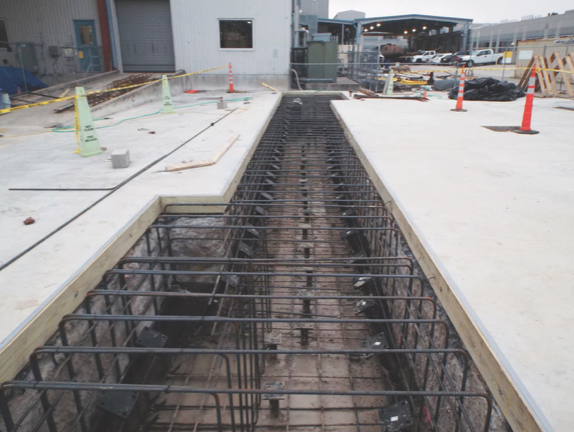 Installing piers to stabilize a commercial foundation for heavy industrial equipment